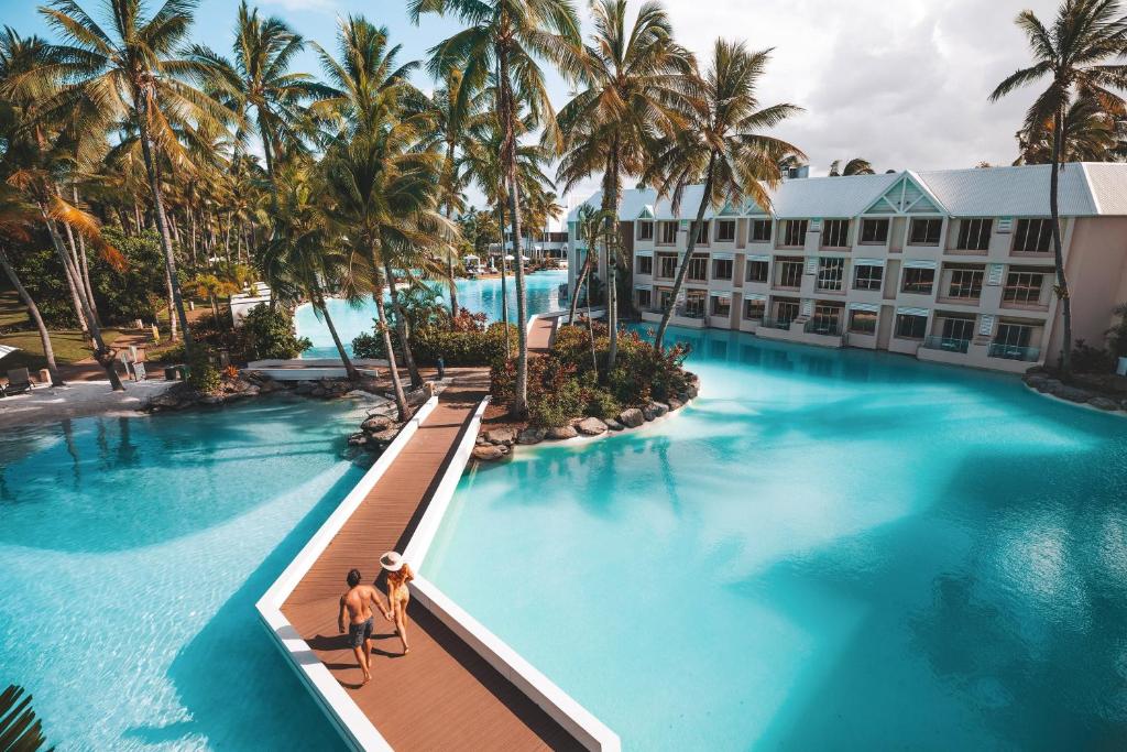 道格拉斯港道格拉斯港喜来登大酒店 的一座棕榈树的酒店游泳池,两人坐在桥上