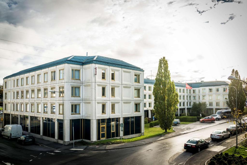 斯德哥尔摩斯卡尔霍尔姆斯堪迪克酒店的一条城市街道上白色的建筑,屋顶蓝色