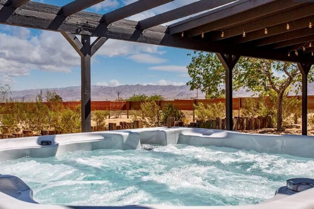 约书亚树Cheerful 2bedroom home with hot tub and cowboy pool in Joshua Tree的后院的热水浴池,享有美景