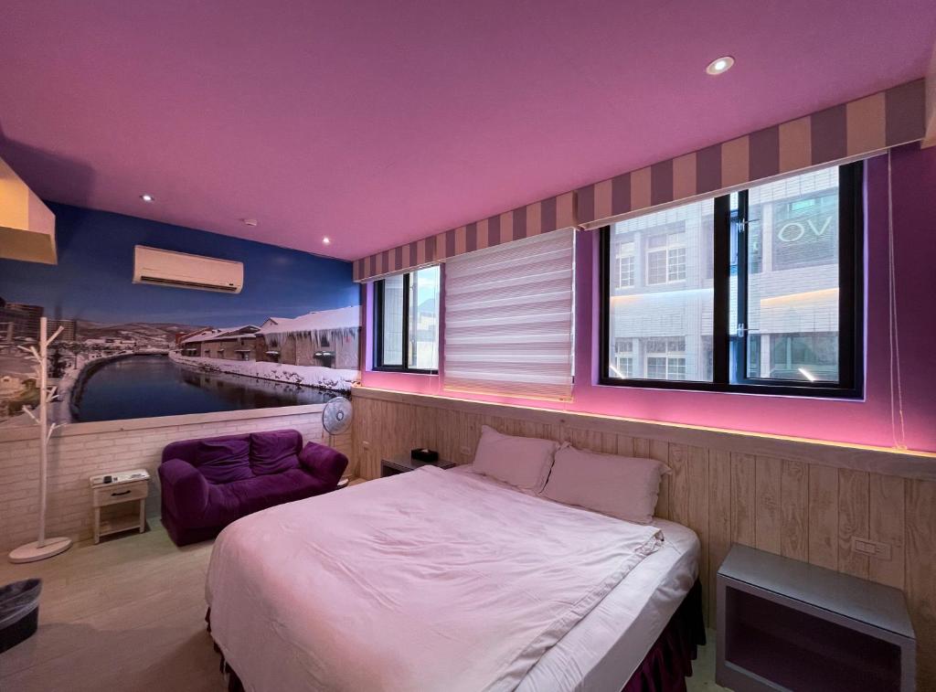 花莲市向往时尚民宿的一间卧室设有一张大床和一个紫色的天花板