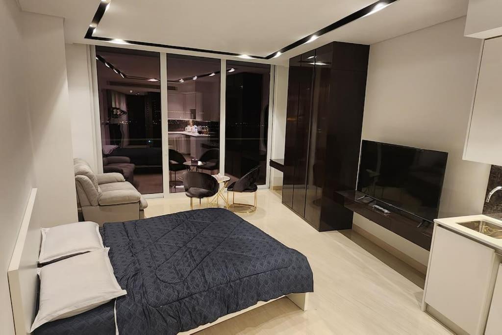 Seefstudio apartment with balcony的一间卧室配有一张床、一张沙发和一台电视
