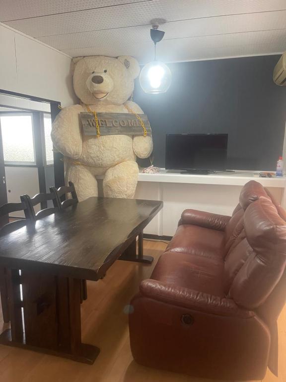 FutaeFRIENDS的一只巨大的泰迪熊站在客厅里