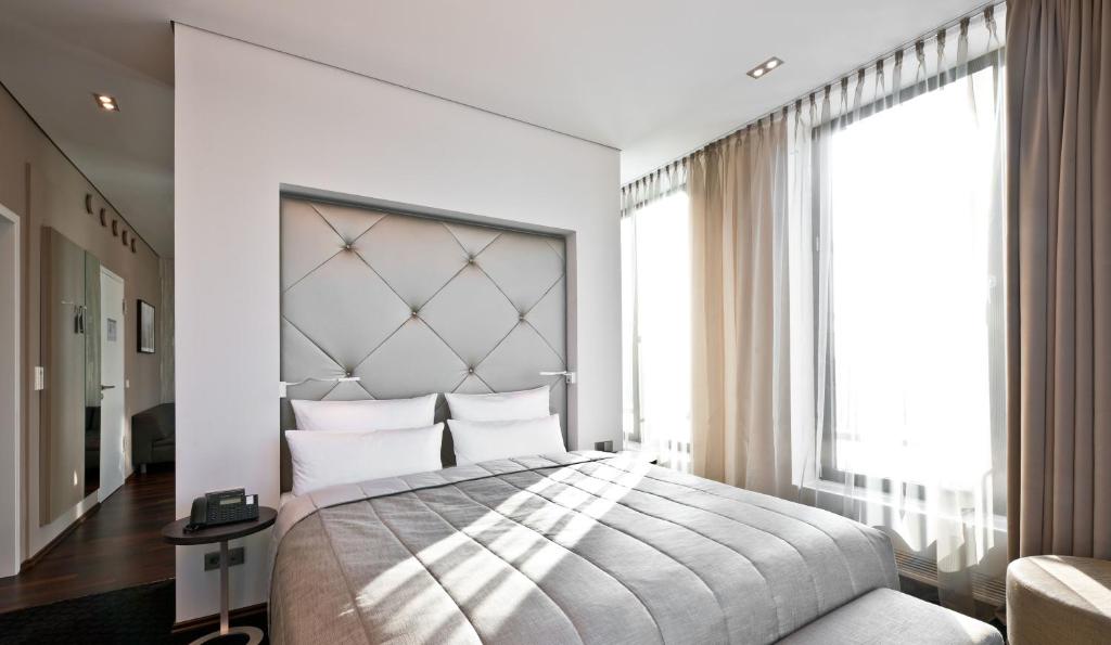 柏林柏灵城中区COSMO酒店的一间卧室设有一张大床和一个大窗户