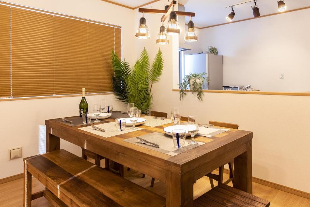 恩纳Y's沖縄リゾートベースNo.1的一间带木桌和椅子的用餐室