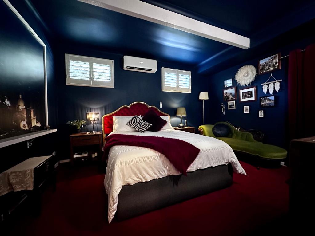 Arthurs SeatArthurs Seat Cottage - Sulla Collina的一间拥有蓝色墙壁的卧室和一张铺有红色床单的床