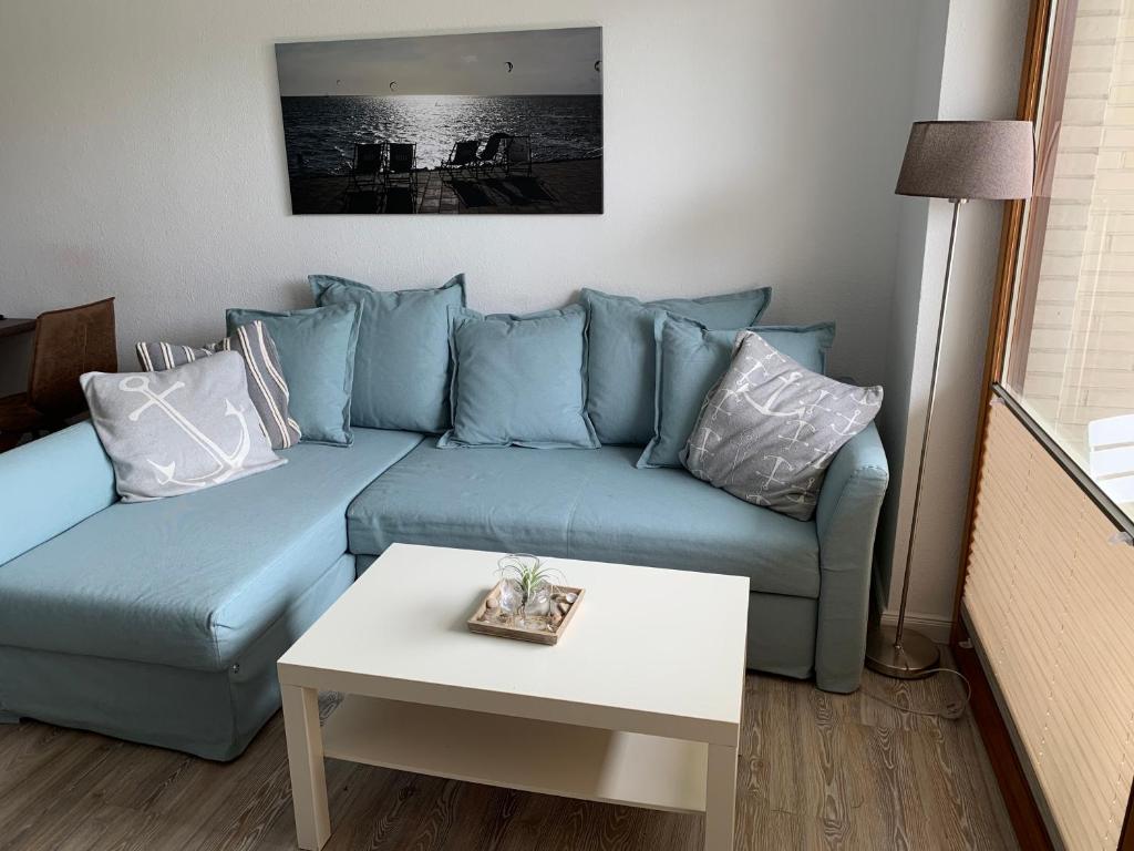 比苏姆Huus Parlbuggt的客厅配有一张蓝色的沙发,配有一张桌子