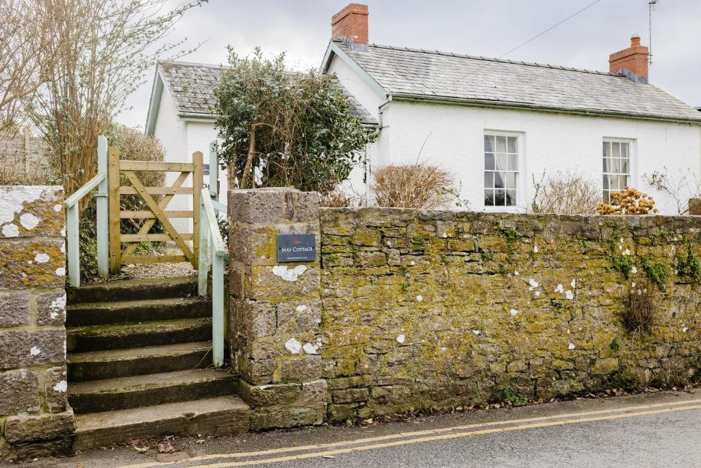 马诺比尔May Tree Cottage Manorbier 5 mins from the beach Sleeps 4的白色房子前面的石墙和楼梯