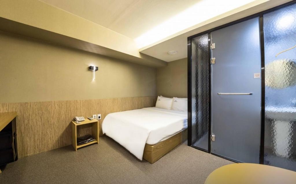 首尔Hotel Daisy的酒店客房,设有床和滑动玻璃门