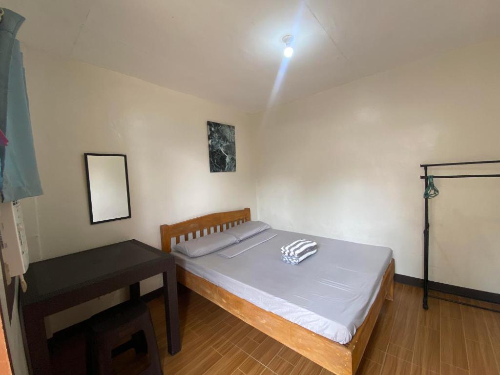 邦劳Alona Bohol Backpackers Hostel的一间卧室配有一张床和一张桌子