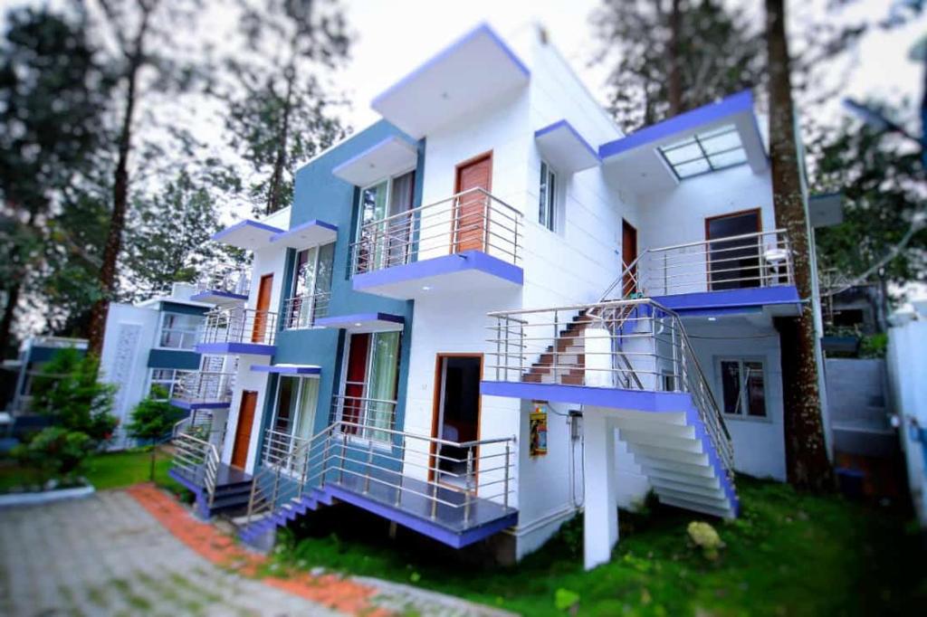 埃尔加德GV Resort的白色和蓝色的房子,有蓝色的楼梯