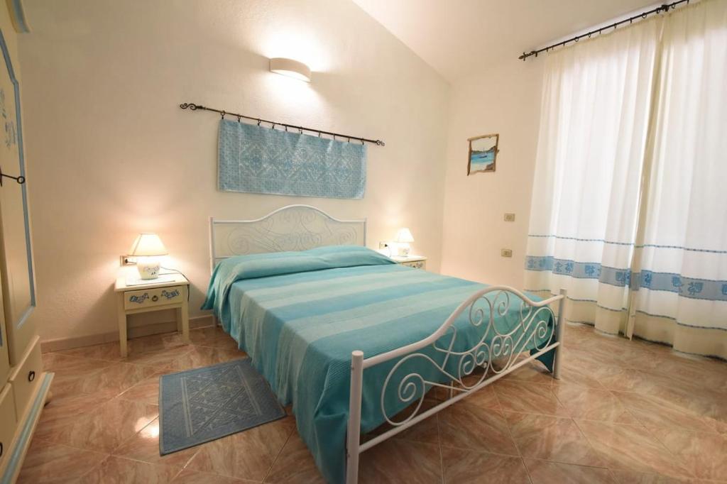 马达莱纳Villetta a schiera的一间卧室配有一张带蓝色毯子的床