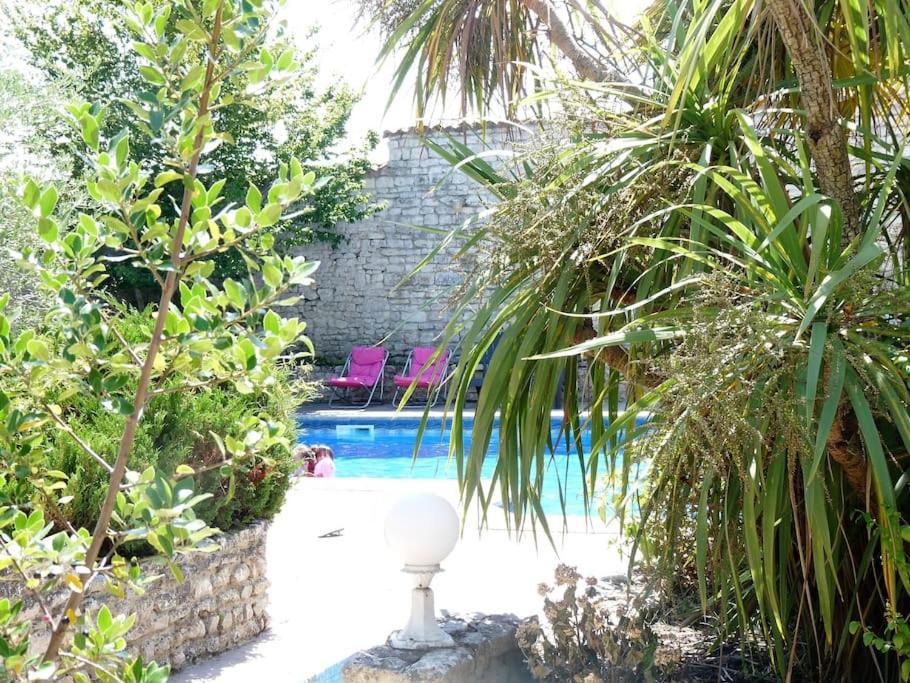 拉弗洛特Villa del Ré 6的棕榈树花园内的游泳池