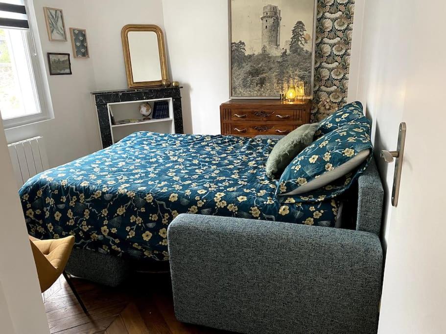蒙雷里studio le 17 près de Paris的一间卧室配有一张带蓝色毯子和椅子的床