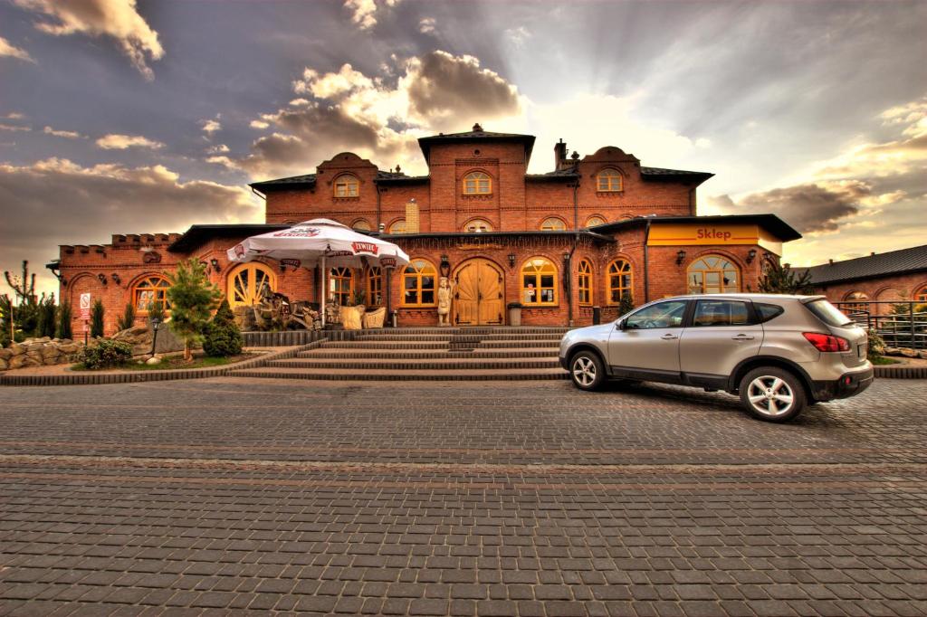 卢布林地区托马舒夫斯塔罗波尔斯卡酒店的停在大楼前的汽车