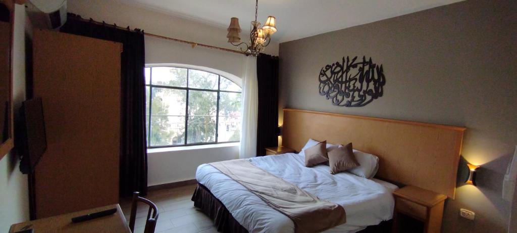 马达巴Moab Land Hotel的一间卧室设有一张大床和大窗户