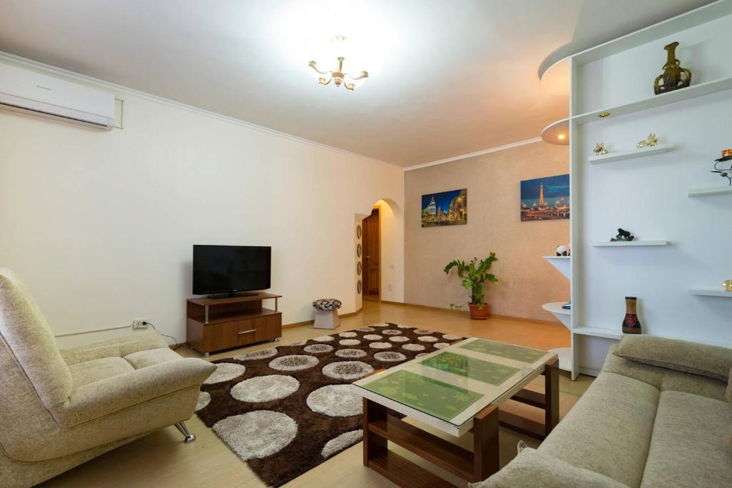阿拉木图西莫尔娜杰日达公寓的客厅配有沙发和桌子