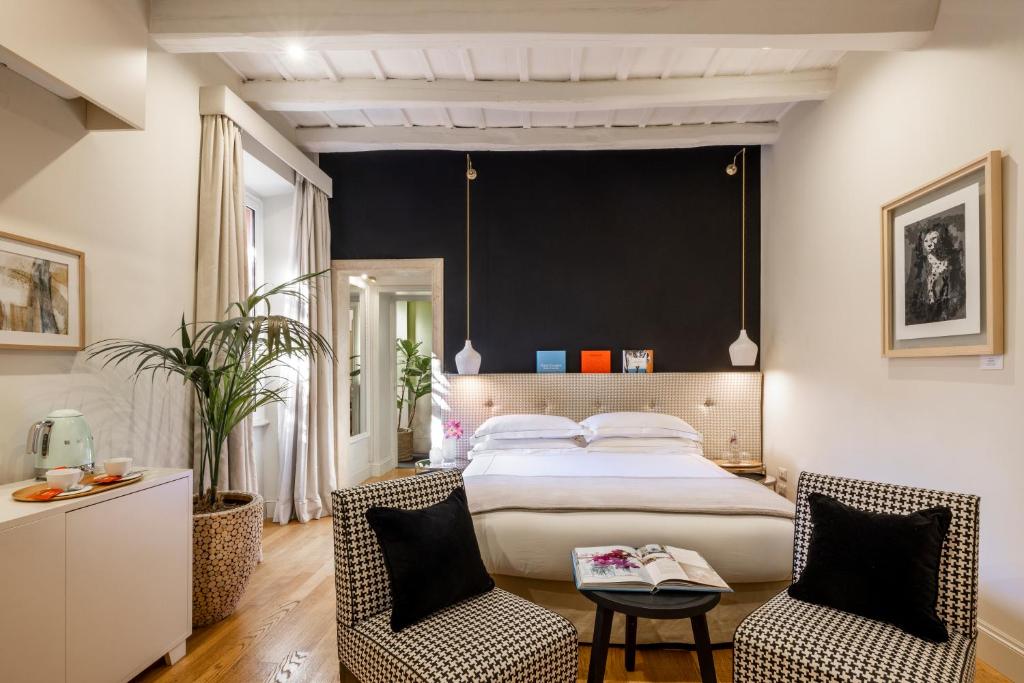罗马涅尔瓦精品酒店 的一间卧室配有一张大床和两把椅子