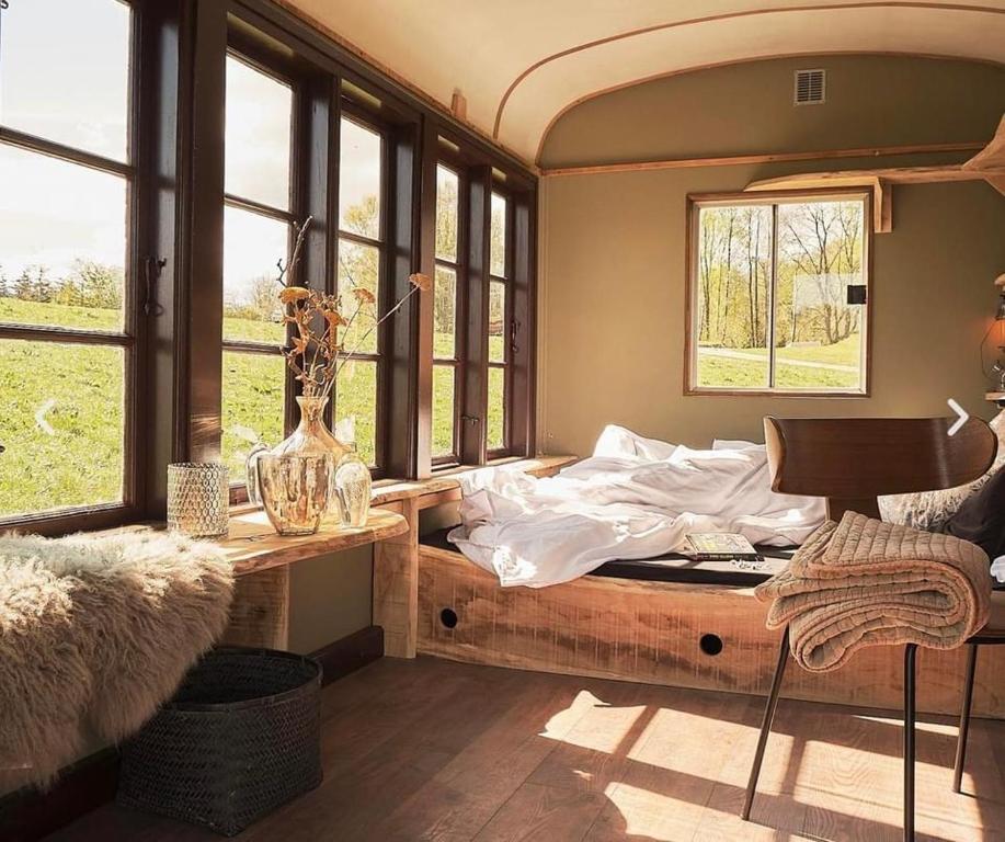 TjeleSol-flora的卧室配有床、桌子和窗户。
