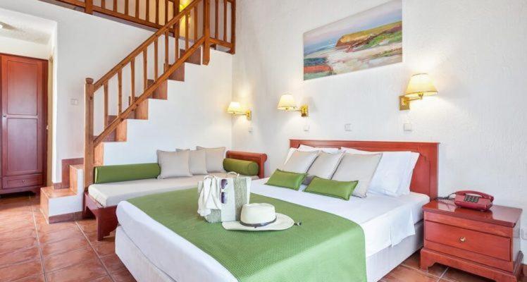 斯科派洛斯Rigas Hotel Skopelos的一间带两张床的卧室和楼梯