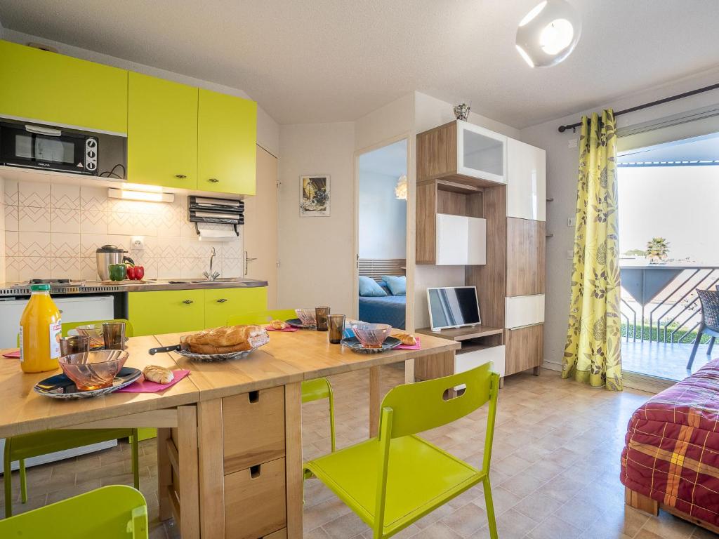 勒格罗-迪鲁瓦Apartment Les Caraïbes-1 by Interhome的厨房配有黄色橱柜和桌椅