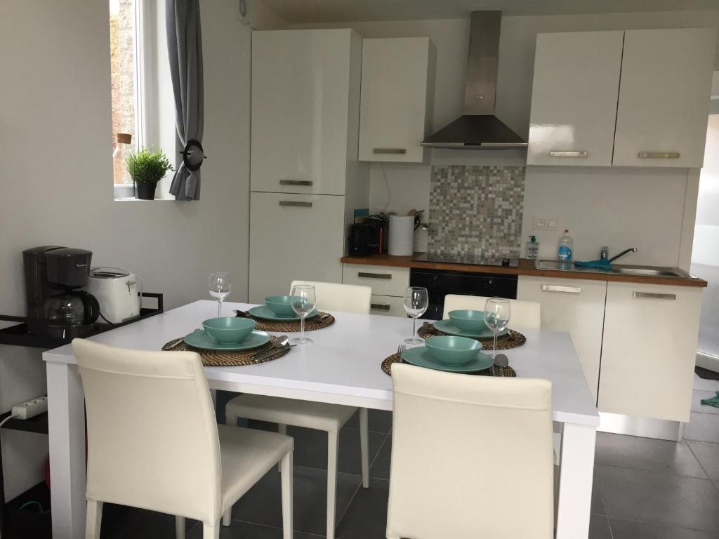 马尔梅迪Les terrasses de Malmedy duplex 420的厨房配有白色的桌椅和桌子。