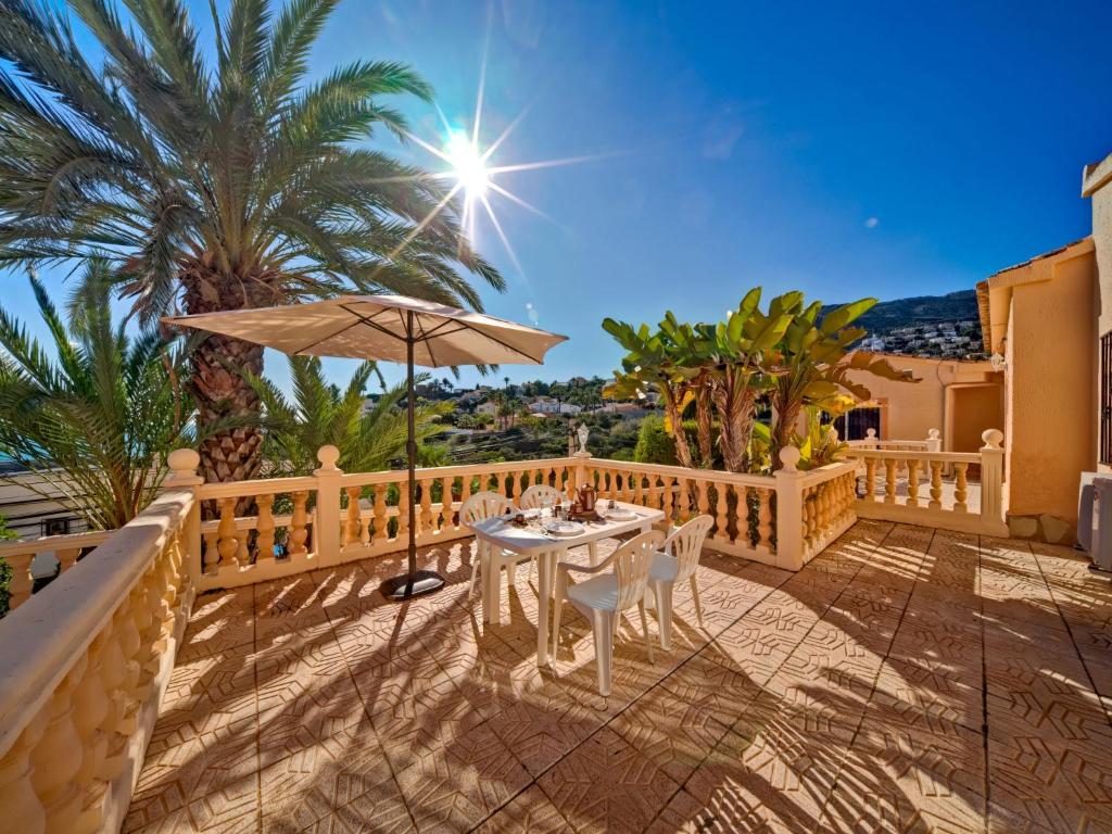 卡尔佩Apartment Canuta Baja 3 by Interhome的一个带桌子和遮阳伞的庭院