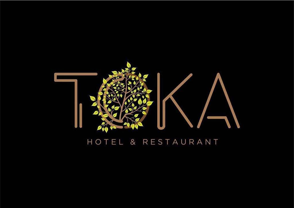 波格拉德茨Toka Hotel Restaurant的树上的酒店和餐厅的标志