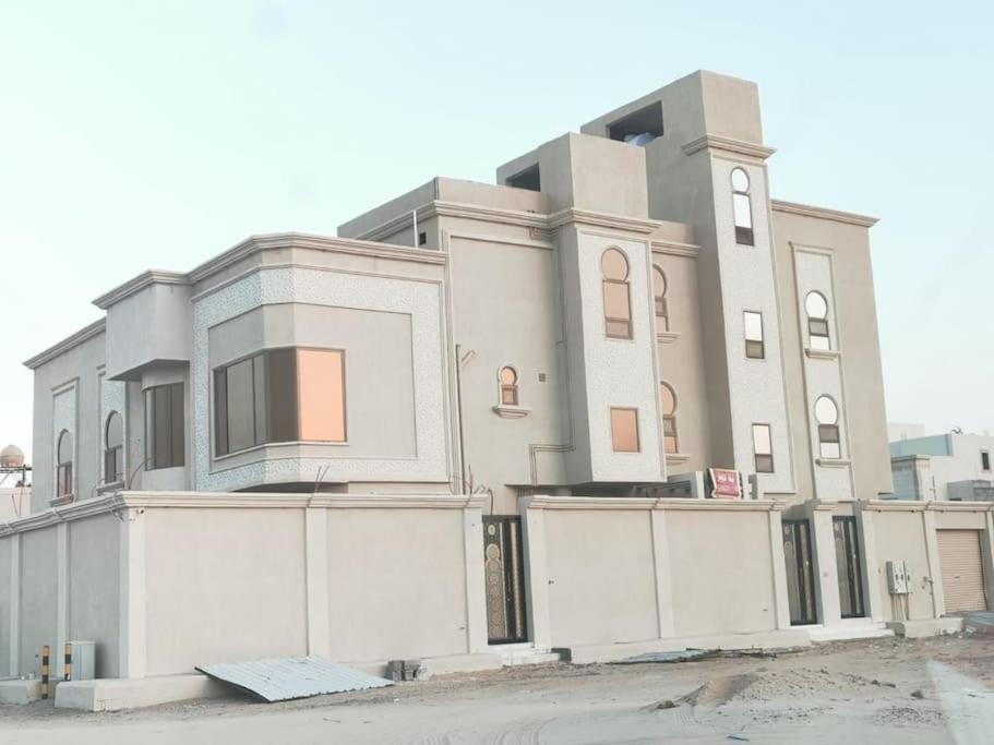 Al Hulaylahشقة مفروشه ومريحة وقريبه من المناطق السياحية عوائل فقط的前面有栅栏的大白色建筑