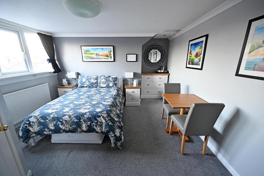 埃文河畔斯特拉特福阿文克特旅馆的一间卧室配有一张床、一张桌子和一张桌子