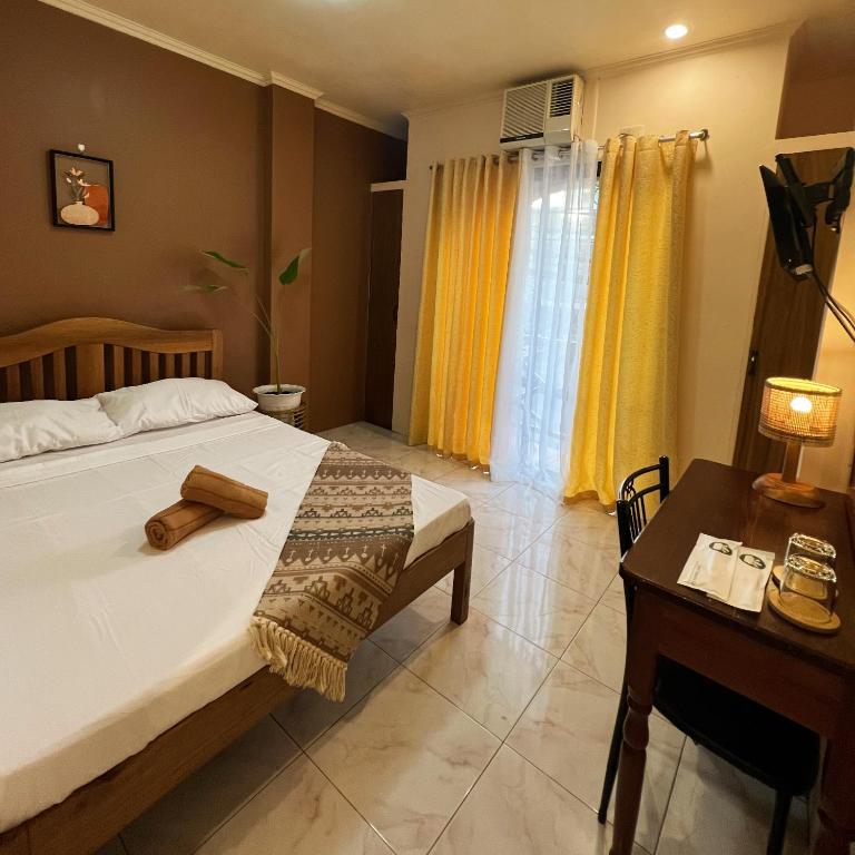 公主港Balayong Pension的一间卧室配有一张床、一张桌子和一张书桌
