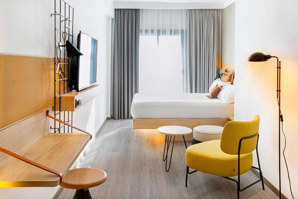 巴塞罗那巴塞罗那博览会酒店的酒店客房,配有床和黄色椅子