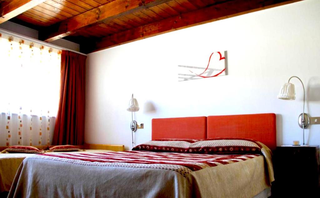 罗韦雷托拉贝图拉乡村民宿的一间卧室配有一张红色床头板的床