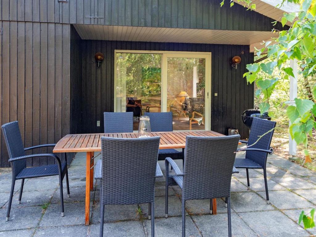 维斯特索马肯Holiday Home Hildegerd - 500m from the sea in Bornholm by Interhome的天井上的木桌和椅子