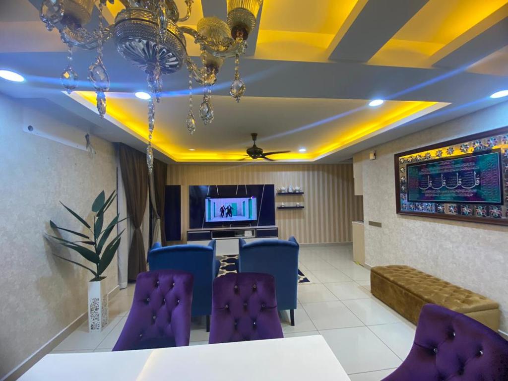 普特拉贾亚D'PUDINA的一间设有紫色椅子和电视的等候室