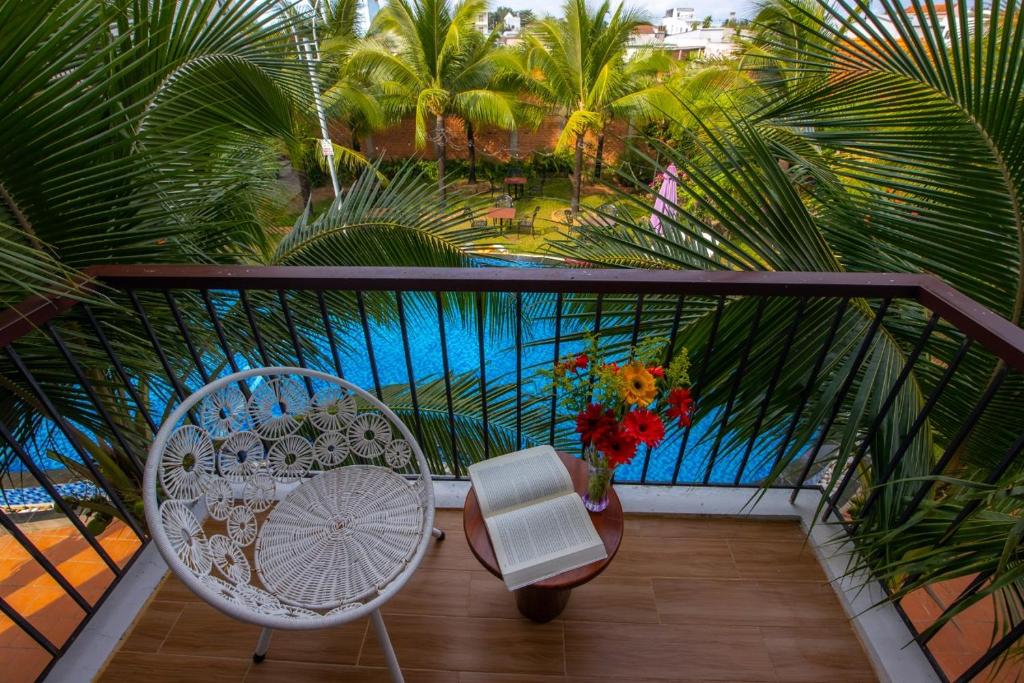 富国洪文度假酒店的阳台配有桌子和椅子,并种植了棕榈树。