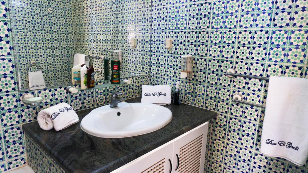 苏塞Dar El Goulli的浴室设有白色水槽和蓝色及白色瓷砖墙。