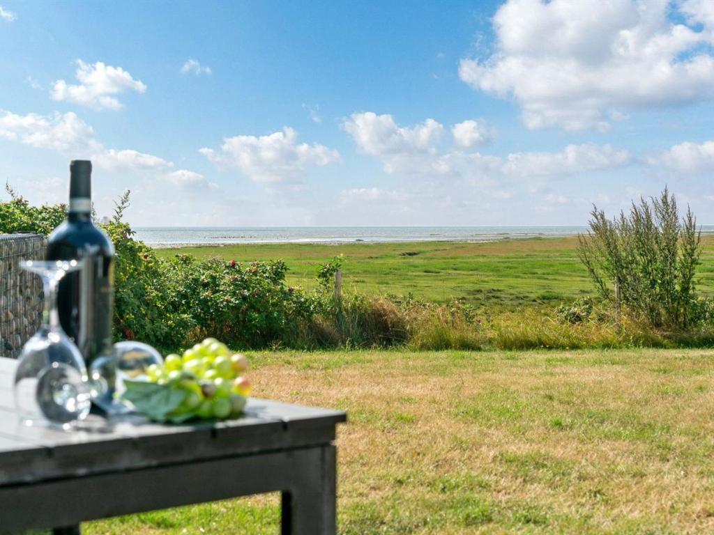 HavnebyHoliday Home Langsom - 100m from the sea in Western Jutland by Interhome的一张桌子,上面放着一瓶葡萄酒和一碗水果