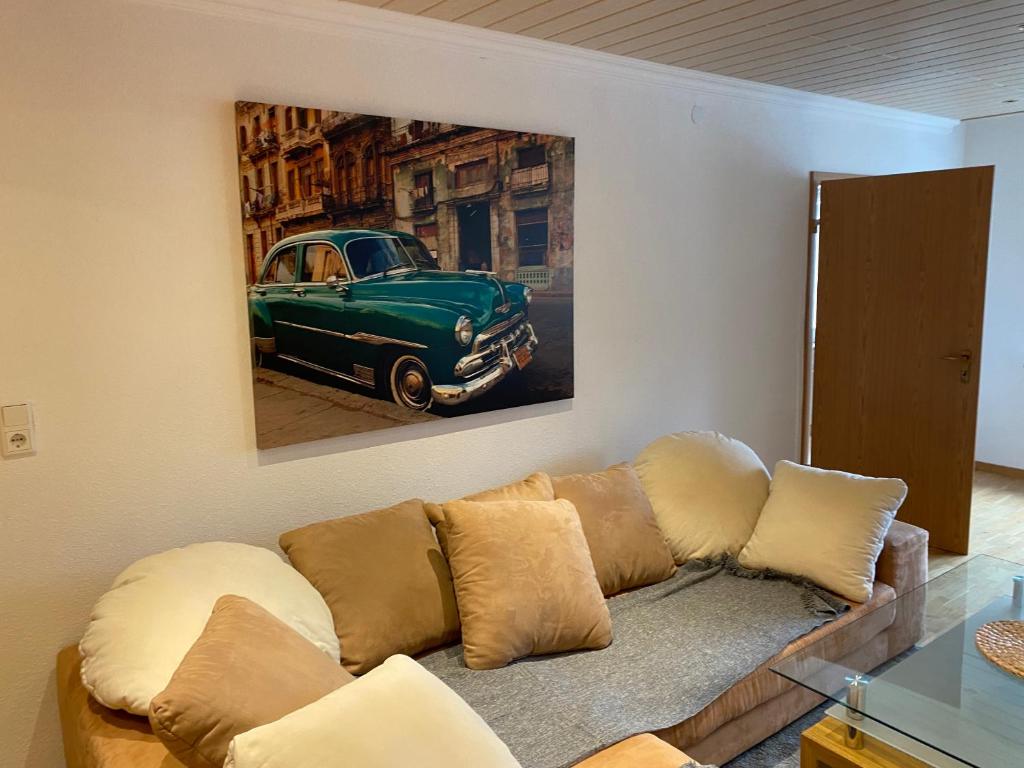 齐恩多夫Ferienhaus-Zirndorf的客厅的沙发,上面有绿色汽车的画作
