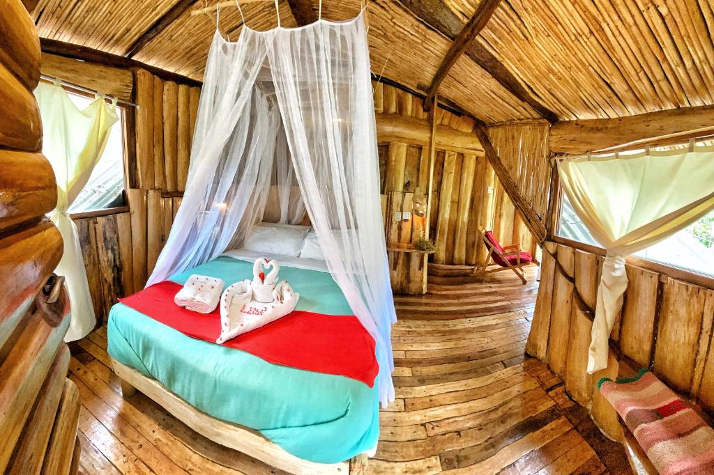 圣特雷莎盖丘亚生态山林小屋的小木屋内一间卧室,配有一张床