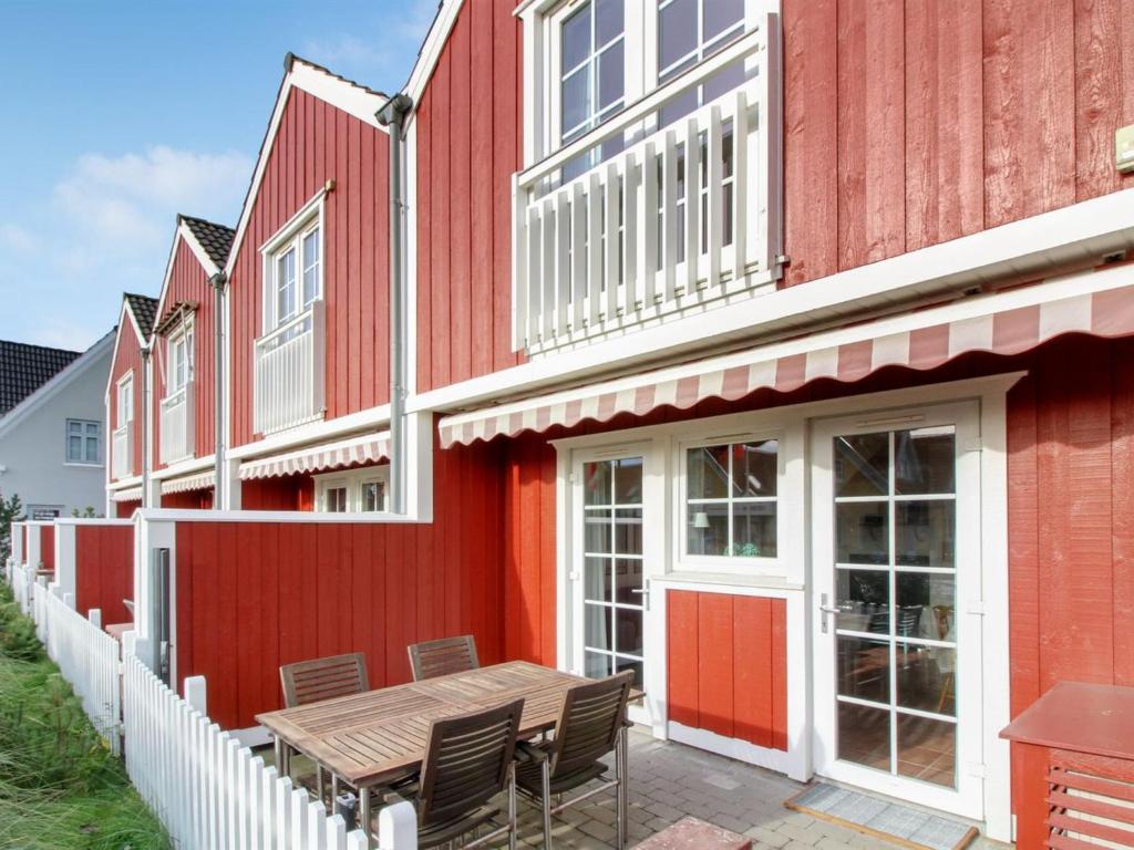 布拉万德Apartment Guthir - 1-2km from the sea in Western Jutland by Interhome的一座红色的建筑,前面设有一张木桌