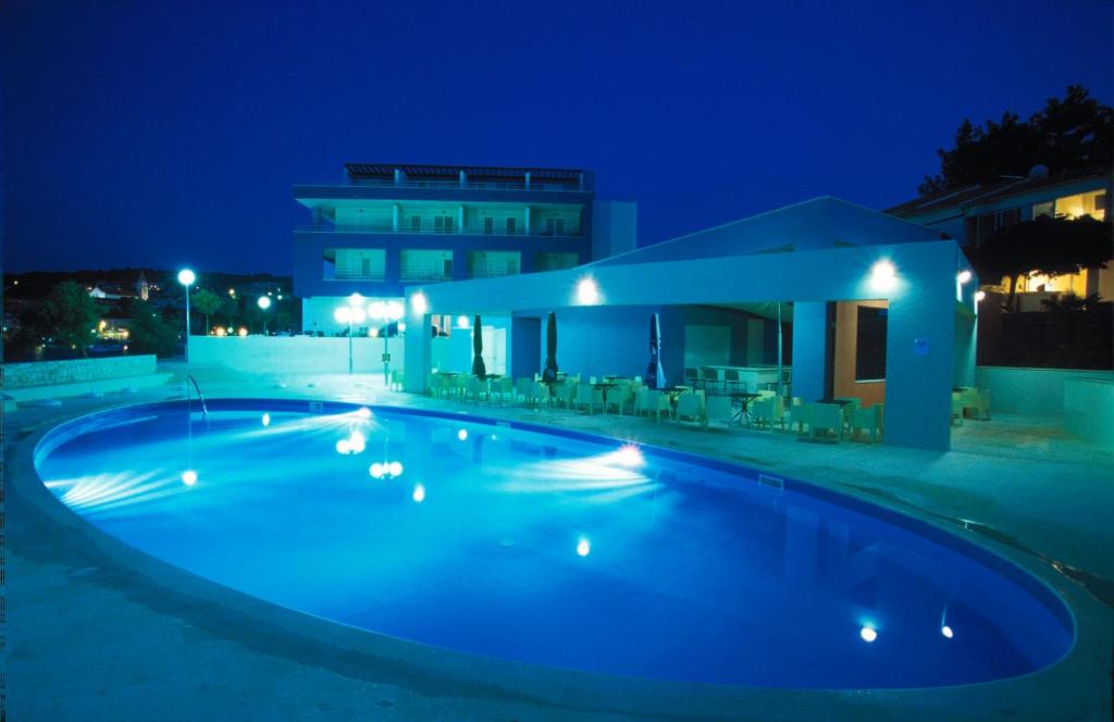 波斯蒂拉玛丽亚公寓的一座游泳池,在晚上在建筑物前