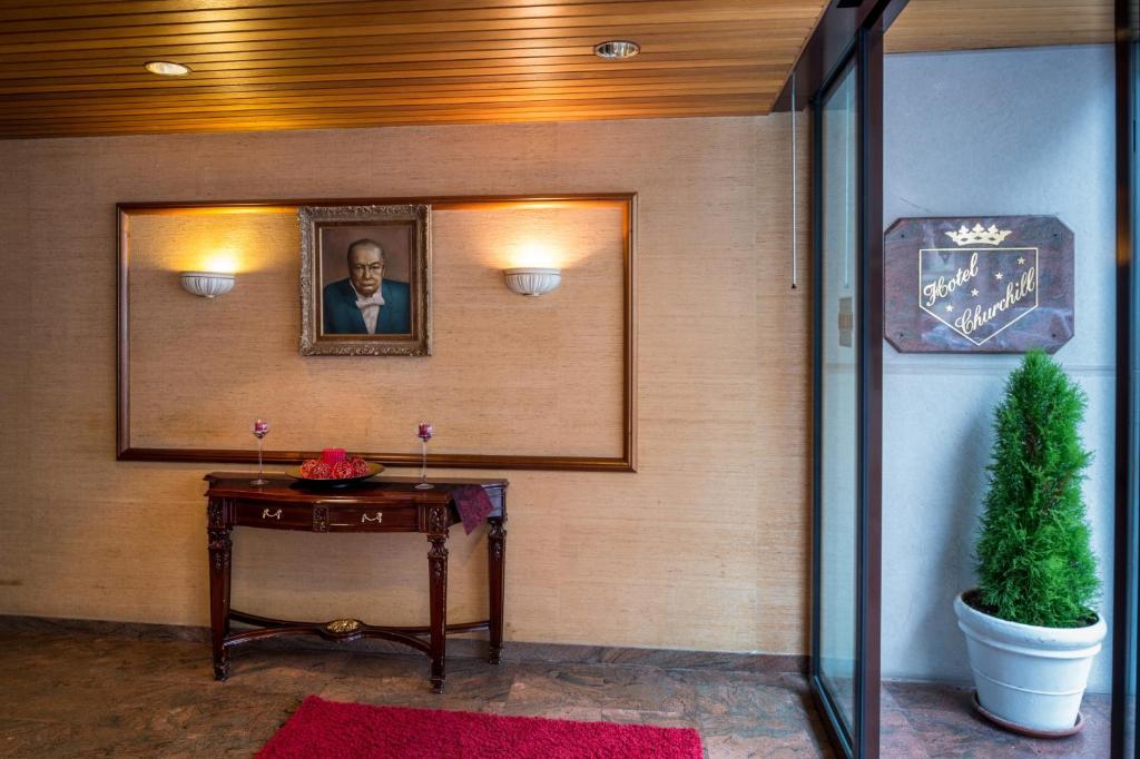日内瓦丘吉尔酒店的一间墙上挂着一张桌子和一张照片的房间
