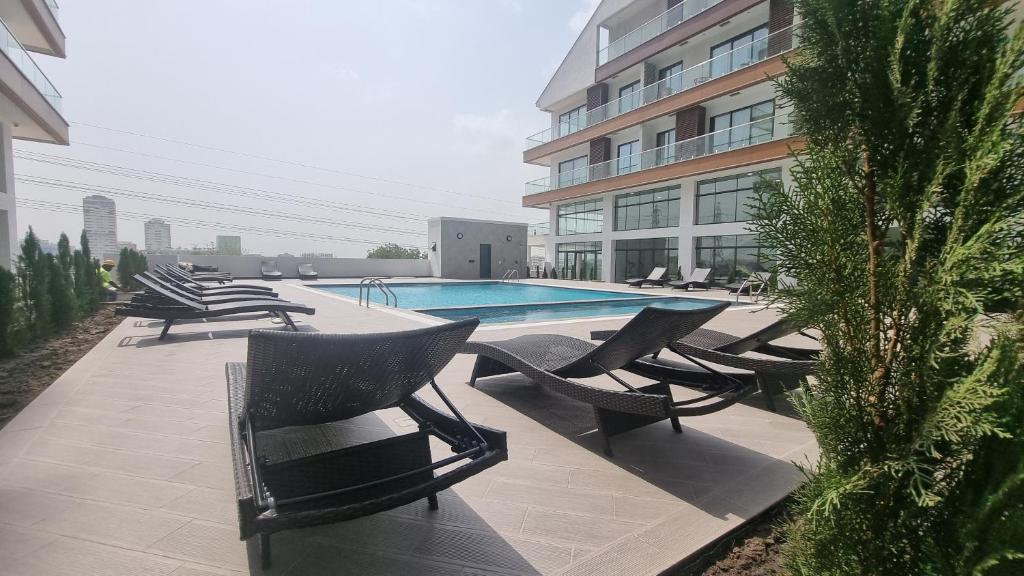 BawaleshiThe Signature Luxury suites CPG的一组椅子坐在游泳池旁
