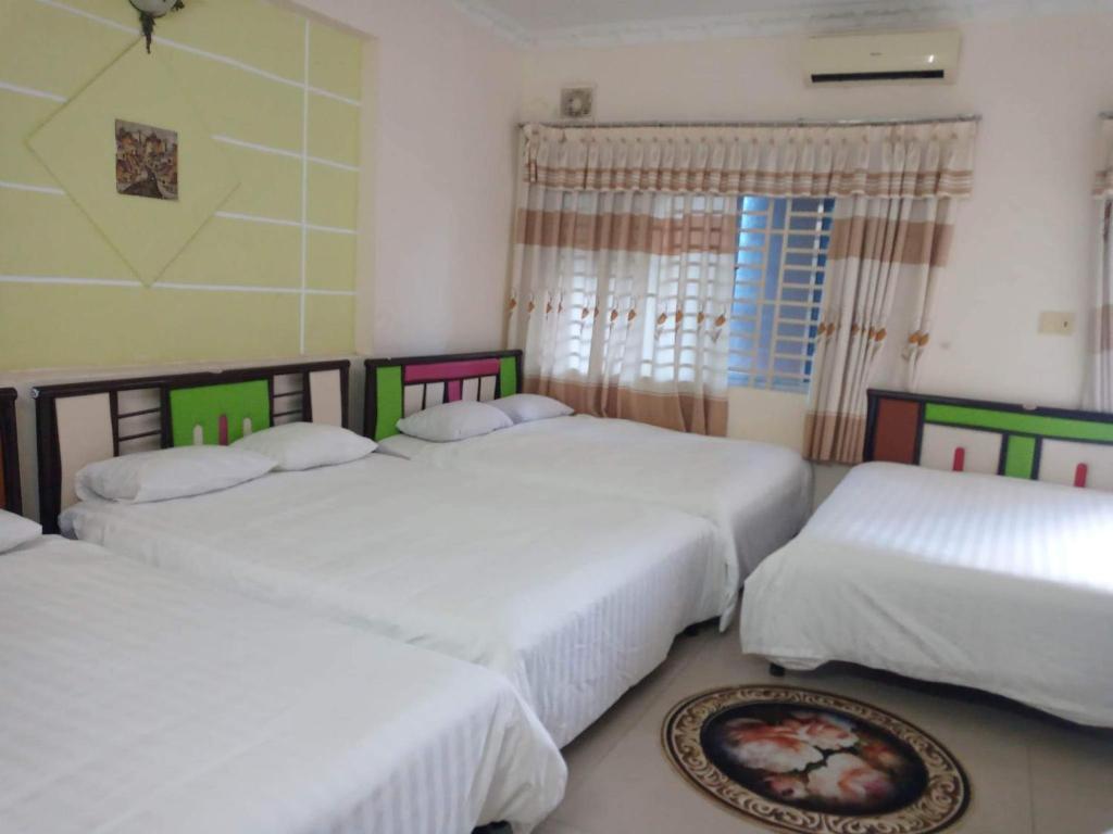 头顿Motel Thanh Huyền的一间卧室设有三张床和窗户。