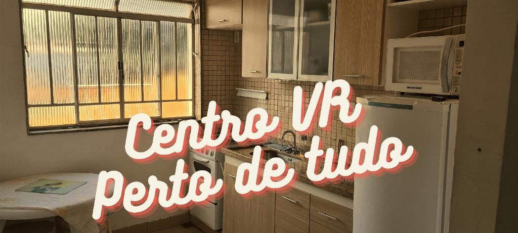 沃尔塔雷东达Apt(2) no centro de VR tudo perto até 7 pessoas的厨房配有白色冰箱,上面有标志,上面写着中间的米必须系上系