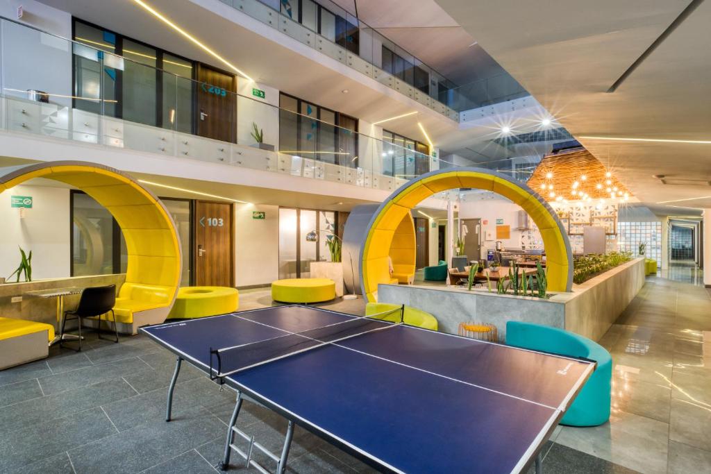提华纳Eazy Rio by ULIV的办公室,配有乒乓球桌和黄色椅子