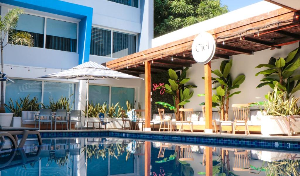 卡塔赫纳蓝色概念酒店的酒店游泳池设有椅子和遮阳伞