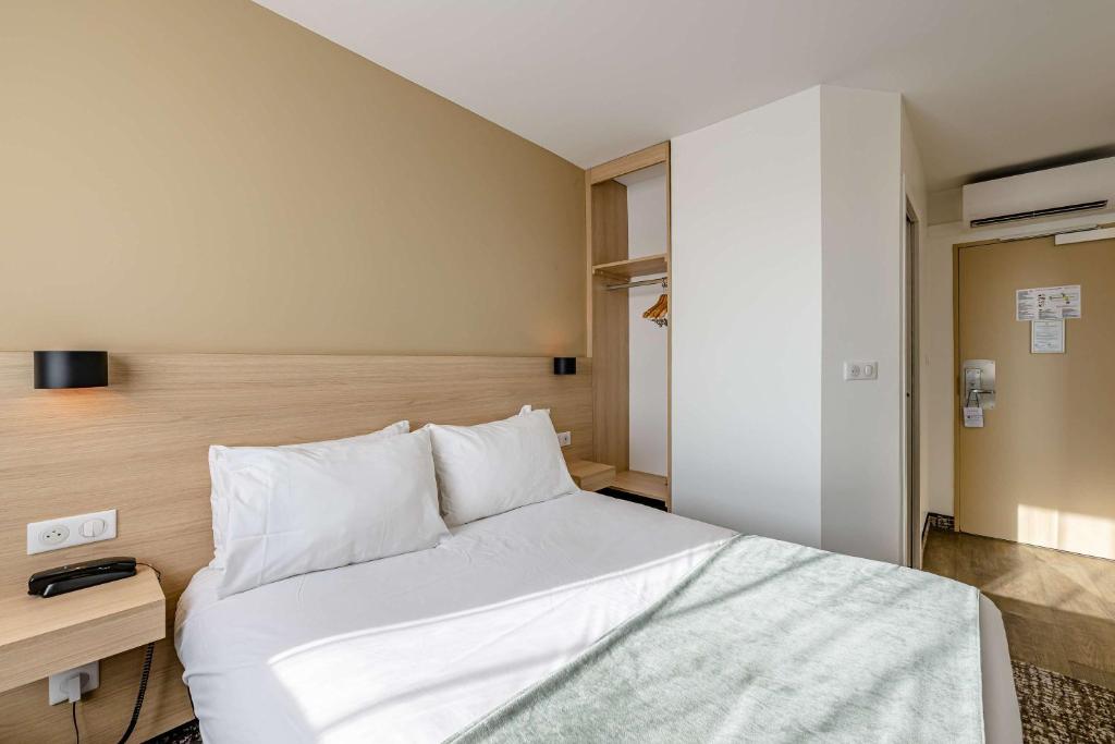 波尔多Sure Hotel by Best Western Bordeaux Lac的卧室配有白色的床和木制床头板