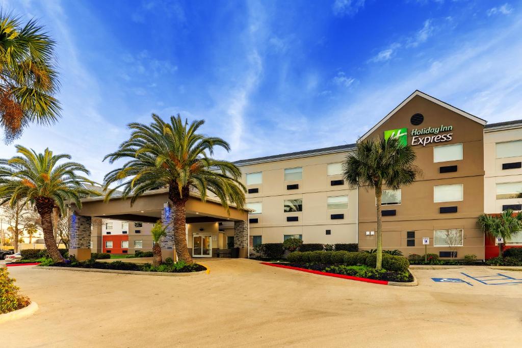 肯纳Holiday Inn Express Kenner - New Orleans Airport, an IHG Hotel的一座楼前有棕榈树的酒店