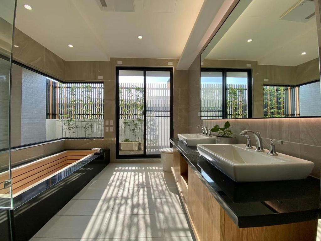 台南安平包棟民宿 - 尋雨 - 台南民宿Ktv影音室限包棟使用的浴室配有两个盥洗盆和浴缸。